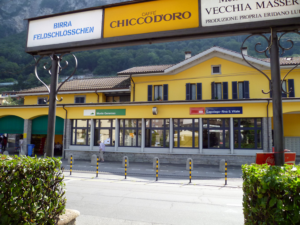 Staniční budova v Capolago. Za ní projíždějí rychlovlaky směrem na Milano