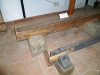 Konstrukce dřevěných trámů s kovovou lištou v kamenných pražcích